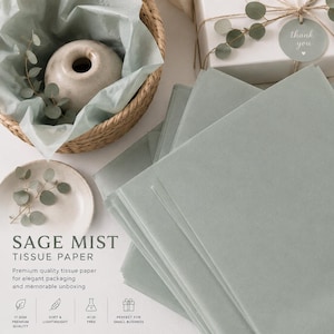 May include: A stack of sage green tissue paper sheets. The image includes text reading SAGE MIST TISSUE PAPER, 17 GSM PREMIUM QUALITY, SOFT & LIGHTWEIGHT, ACID FREE, and PERFECT FOR SMALL BUSINESS, alongside a woven basket and a gift box.