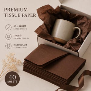 May include: A stack of 40 sheets of dark brown premium tissue paper measuring 50 x 70 cm, with a 17 GSM quality rating. The set includes a white gift box lined with crinkled brown tissue paper containing a beige ceramic mug and a brown ribbon.