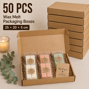 May include: A set of 50 brown cardboard wax melt packaging boxes measuring 25 x 20 x 5 cm. The open box contains three clear plastic clamshells filled with white, pink, and green wax melts, plus a thank you card on brown paper filler.