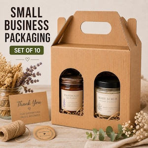 Könnte beinhalten: Eine braune Geschenkbox aus Wellpappe mit Tragegriff und zwei Bogenfenstern, die ein Glas Lavendel-Sojakerze und ein Glas Kokos-Vanille-Körperpeeling zeigen, begleitet von einer Dankeskarte und einer Rolle Paketschnur.