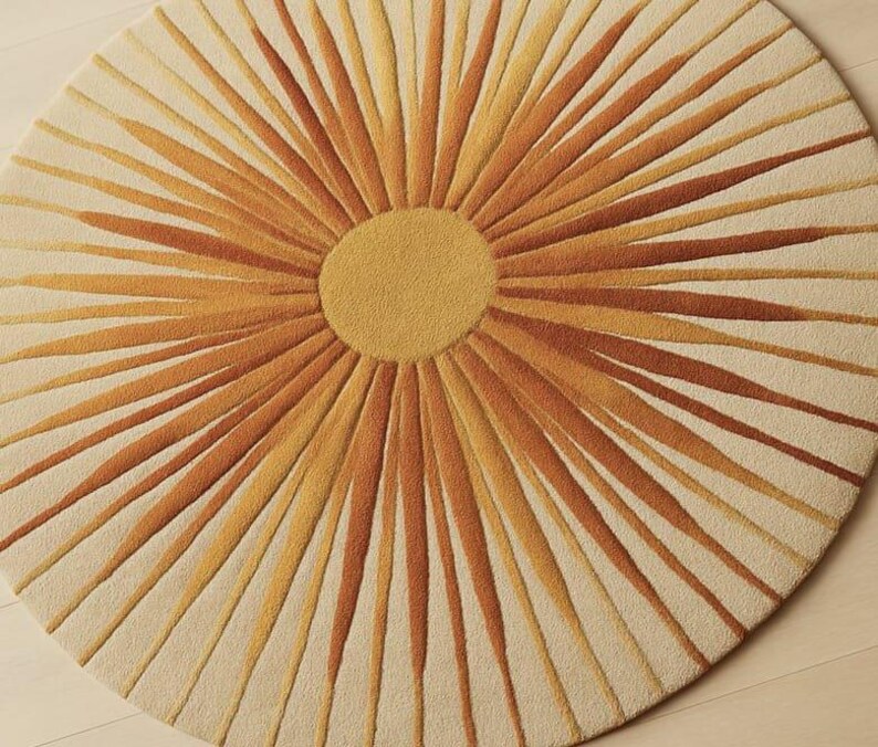 Puede incluir: Una alfombra redonda con dise&ntilde;o de sol. Presenta un c&iacute;rculo central amarillo con rayos naranjas y amarillos sobre un fondo crema. La alfombra est&aacute; hecha de un material suave y texturizado. Di&aacute;metro aproximado de 150 cm.