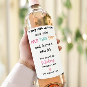 Puede incluir: Una botella de vino transparente con una etiqueta rosa y una tapa rosa. La etiqueta dice: "Una mujer muy sabia dijo una vez FUCK THIS SHIT y encontró un nuevo trabajo, ahora ve y sé fabulosa en otro lugar tu mensaje aquí".