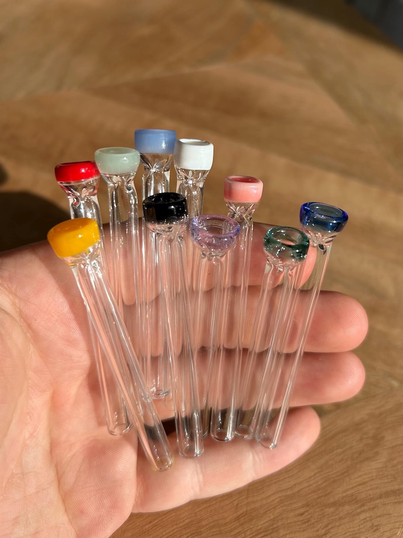 Puede incluir: Una colecci&oacute;n de 12 pipas para fumar de vidrio con puntas de vidrio de colores. Las puntas son de varios colores, incluyendo rojo, amarillo, verde, azul, rosa y blanco.