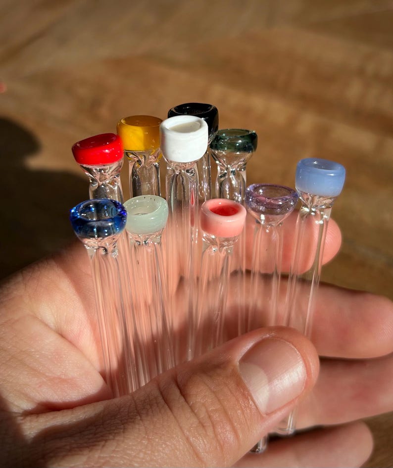 Puede incluir: Una colecci&oacute;n de diez pipas para fumar de vidrio con puntas de vidrio de colores. Las puntas son rojas, amarillas, blancas, negras, verdes, moradas, azules, azules claras, rosas y verdes claras.