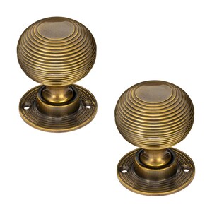 K&ouml;nnte beinhalten: Zwei antike T&uuml;rkn&ouml;pfe aus Messing. Jeder Knopf hat eine kugelf&ouml;rmige Form mit konzentrischen Rillen, die auf einer kreisf&ouml;rmigen Basis montiert sind. Das Messing hat eine warme, gealterte Patina, die auf Vintage-Hardware hindeutet.