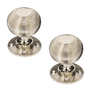 K&ouml;nnte beinhalten: Zwei T&uuml;rkn&ouml;pfe aus poliertem Nickel. Jeder Knopf hat eine kugelf&ouml;rmige Form mit konzentrischen Rillen und einer kreisf&ouml;rmigen Basis. Die Beschl&auml;ge sind aus Metall und haben eine gl&auml;nzende, reflektierende Oberfl&auml;che. F&uuml;r eine T&uuml;r.