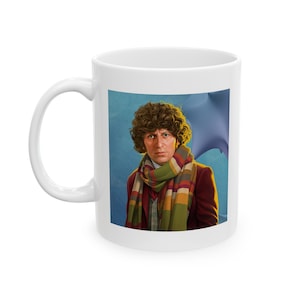 May include: White ceramic mug with a colorful illustration of a man with curly brown hair wearing a multi-colored scarf and a brown jacket. The background is a blue and white gradient.