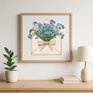 May include: A framed print depicting a bouquet of blue flowers emerging from a cream envelope, secured with a beige lace bow. The artwork is set against a white backdrop and framed in light wood. The theme is floral and romantic, suitable for home decor.