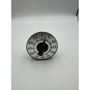 May include: A black and silver kitchen timer with a dial that reads up to 55 minutes. The timer has a black knob and the brand name "Sunbeam" is printed on the face. The numbers are in black against a silver background.