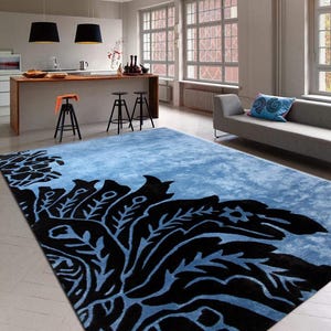 May include: A blue and black area rug with a floral design. The rug has a distressed look and is made of a soft, plush material.