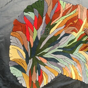 Pode incluir: Um tapete abstrato colorido com uma forma org&acirc;nica &uacute;nica. O tapete apresenta uma variedade de cores, incluindo vermelho, laranja, amarelo, verde, azul e cinza. O tapete &eacute; feito de um material macio e felpudo e adicionaria um toque de estilo moderno a qualquer c&ocirc;modo.