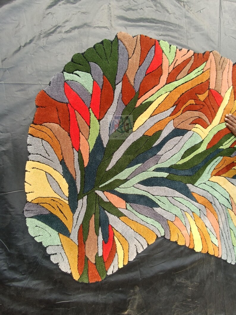 Pode incluir: Um tapete abstrato colorido com uma forma org&acirc;nica &uacute;nica. O tapete apresenta uma variedade de cores, incluindo vermelho, laranja, amarelo, verde, azul e cinza. O tapete &eacute; feito de um material macio e felpudo e adicionaria um toque de estilo moderno a qualquer c&ocirc;modo.