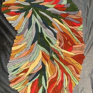 Pode incluir: Tapete abstrato com um design de folha em tons de verde, vermelho, amarelo, laranja e cinza. O tapete &eacute; feito de l&atilde; tufada &agrave; m&atilde;o e tem um estilo moderno &uacute;nico.