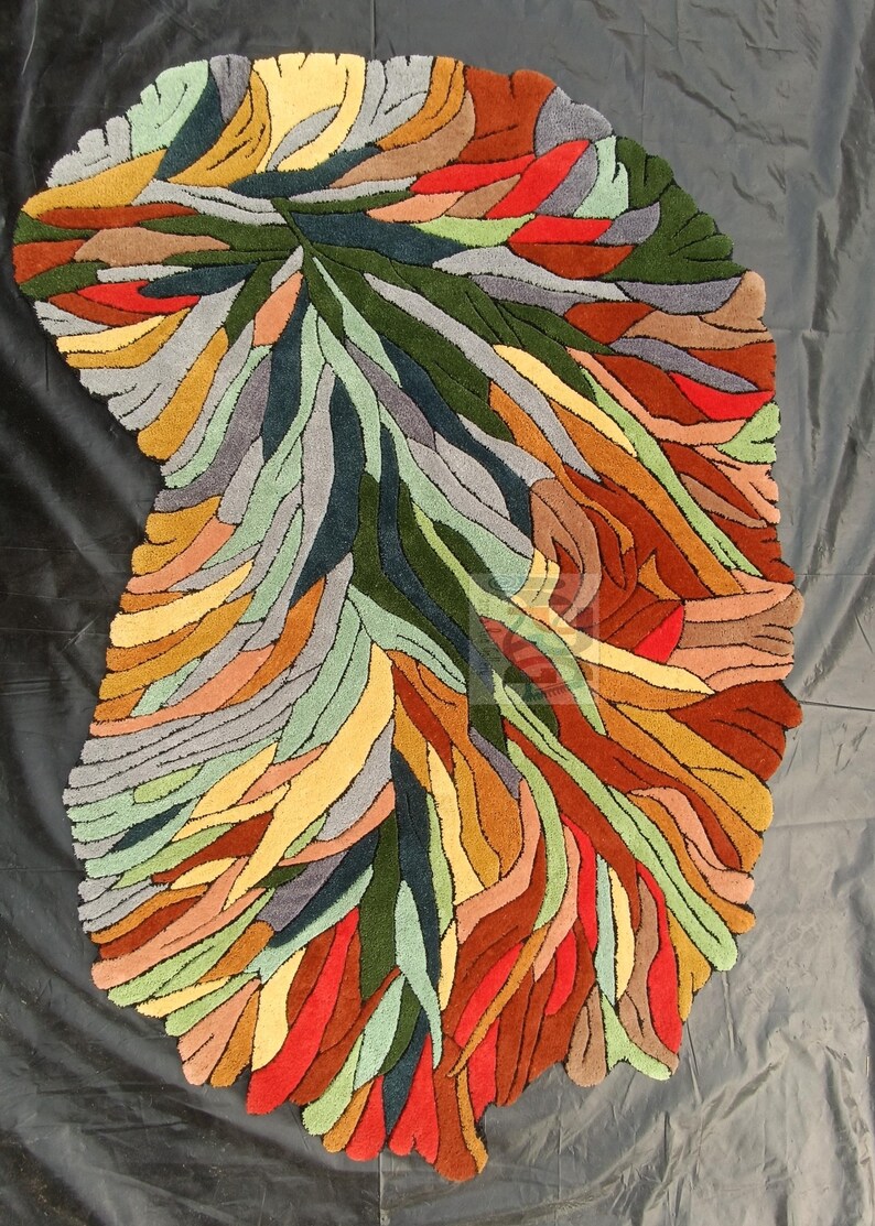Pode incluir: Tapete abstrato com um design de folha em tons de verde, vermelho, amarelo, laranja e cinza. O tapete &eacute; feito de l&atilde; tufada &agrave; m&atilde;o e tem um estilo moderno &uacute;nico.