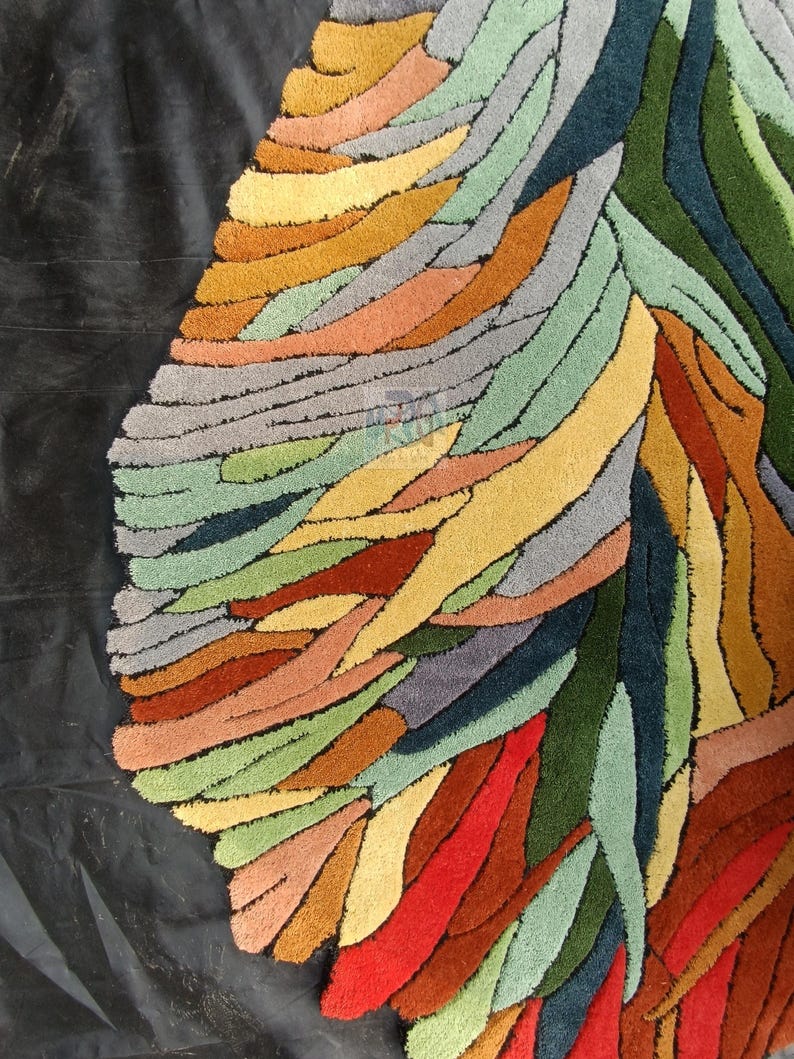 Pode incluir: Um tapete abstrato colorido com um design de formas sobrepostas e em camadas em tons de verde, azul, vermelho, laranja, amarelo e marrom.