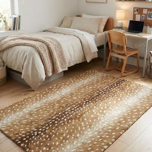 May include: A rectangular area rug featuring a brown and white spotted pattern that mimics the appearance of a deer hide. The rug has a soft, textured surface with a gradient of darker brown tones along the center and lighter white spots.