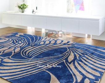 Può includere: Un tappeto astratto blu e beige con il testo "Panama Rug Gallery" al centro.