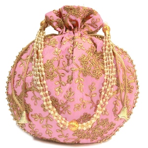 Può includere: Una borsa a cordoncino rosa con ricami dorati e un pendente di perle e oro. La borsa è decorata con un motivo floreale.