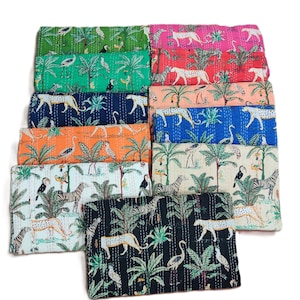 May include: A stack of colorful kantha quilts with a tropical jungle print featuring zebras, leopards, toucans, and flamingos. The quilts are made of cotton and have a hand-stitched design.
