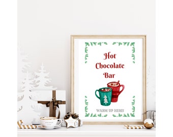 Puede incluir: Un cartel imprimible para una barra de chocolate caliente con fondo blanco y borde de ramas de pino verdes. El cartel dice "Barra de chocolate caliente" con dos tazas de chocolate caliente con malvaviscos y un palo de canela. El texto debajo de las tazas dice "¡Calienta aquí!"