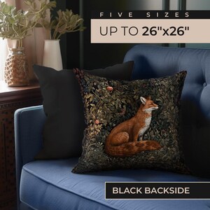 May include: A blue velvet couch with a black and brown throw pillow featuring a fox in a forest scene. The pillow has a black backside. The text "FIVE SIZES UP TO 26"x26" BLACK BACKSIDE" is visible on the couch.