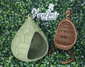 Könnte beinhalten: Eine salbeigrüne, tropfenförmige Kapsel mit geometrischem Gittermuster und ein brauner hängender Eiersessel mit vertikalem Lamellendesign. Ein weißes Schild mit dem Text Hardini's 3D MINIS befindet sich zwischen den beiden Objekten.