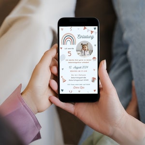 Op de afbeelding: Een mobiele telefoon die een verjaardagsuitnodiging weergeeft met een regenboogontwerp, een foto van een kind en de tekst "Einladung" (Duits voor "Uitnodiging"). De uitnodiging bevat details zoals de leeftijd van het kind, de datum en tijd van het feest en het adres.
