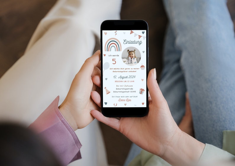 Op de afbeelding: Een mobiele telefoon die een verjaardagsuitnodiging weergeeft met een regenboogontwerp, een foto van een kind en de tekst "Einladung" (Duits voor "Uitnodiging"). De uitnodiging bevat details zoals de leeftijd van het kind, de datum en tijd van het feest en het adres.