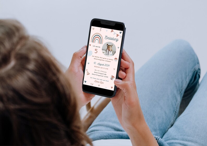 Op de afbeelding: Een smartphone die een kleurrijke verjaardagsuitnodiging toont met een regenboog, vlaggetjes en een foto van een jong kind. De uitnodigingstekst luidt "Einladung" en bevat de datum "12. August 2024".