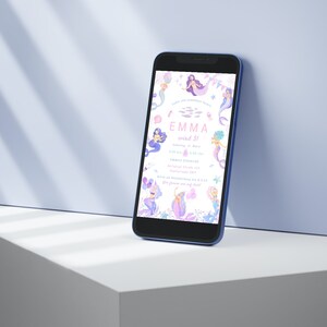 May include: A smartphone displays a mermaid-themed invitation with the text "EMMA wird 3!". The invitation features illustrations of mermaids, stars, and aquatic elements in shades of purple, pink, and blue. The phone has a blue frame.