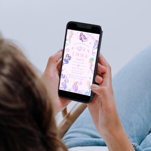 May include: A smartphone displays a mermaid-themed birthday invitation. The invitation features illustrations of mermaids, fish, and aquatic plants in shades of purple, blue, and pink. The text reads "Emma, wird 3!" and includes event details.