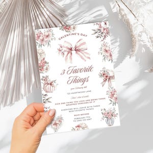 May include: A pink and white Galentine's Day party invitation with floral illustrations and a pink bow. The invitation reads "3 Favorite Things" and includes the date, time, and location of the event. RSVP information is also included.