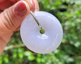 Può includere: Un ciondolo in giada lavanda pallido a forma di ciambella con un'anellina in argento.