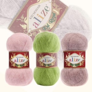 May include: Three balls of yarn in pink, green, and light brown. The yarn is soft and fluffy, and the label says "Alize Kid Royal Kid Mohair".