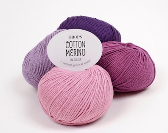 May include: Three balls of yarn in shades of purple and pink. The label reads "DROPS COTTON MERINO UNI COLOUR A superwash yarn for all seasons!"