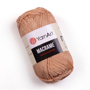 Light brown color yarn skein in white background. 100% polyester yarn. YarnArt macrame cord.