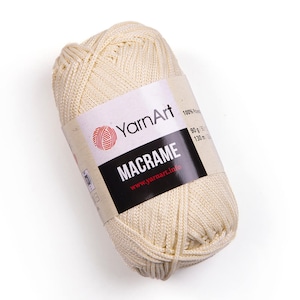 Beige color yarn skein in white background. 100% polyester yarn. YarnArt macrame cord.