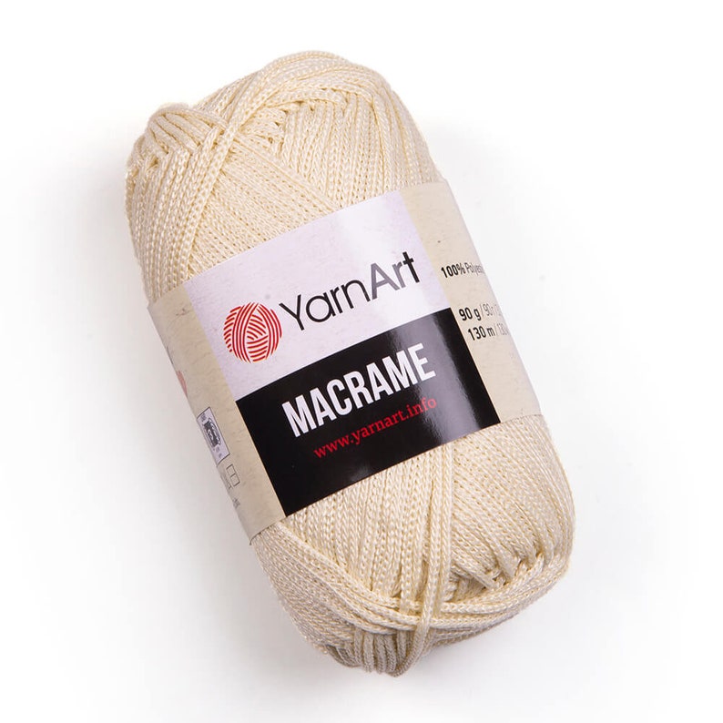 Beige color yarn skein in white background. 100% polyester yarn. YarnArt macrame cord.
