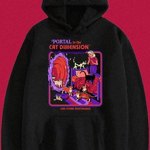 May include: Black hoodie with a graphic print of a portal to the "Cat Dimension" with a girl standing in front of it and many cats surrounding her. The text reads "Portal to the Cat Dimension" and "And Other Nightmares!"