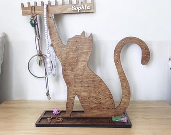Pode incluir: Suporte de joias de madeira em forma de gato com uma placa de nome que diz "Sophia". O suporte tem um rack para colares e uma bandeja para anéis e brincos.