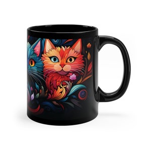 May include: Black coffee mug with a colorful illustration of two cats with floral designs. The cats have bright blue, orange, and red fur.