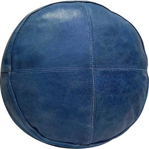 May include: A round, blue leather pouf with a stitched design. The pouf is made of a soft, textured leather and has a slightly distressed look.