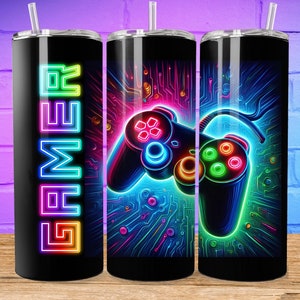May include: Three stainless steel tumblers with a neon gamer design. The tumblers feature a neon green, blue, and pink video game controller with the word "GAMER" in neon colors on the left tumbler.