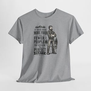 A dark gray short-sleeve t-shirt with a graphic of a lumberjack and text that reads IF THERE WERE MORE FOOD AND FEWER PEOPLE THIS WOULD BE THE PERFECT PARTY.
