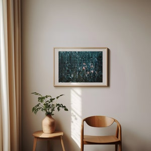 May include: A framed abstract art print with a teal and green color scheme. The print is hanging on a white wall in a room with a wooden chair and a potted plant.