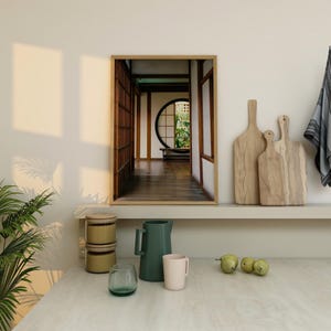 Puede incluir: Una fotografía enmarcada de un pasillo de estilo japonés con una ventana redonda y suelo de madera. El pasillo está decorado con elementos tradicionales japoneses, como puertas correderas y un tatami.