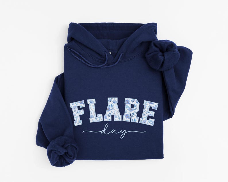 May include: A navy blue hoodie with a white floral print that says "FLARE day" on the front.