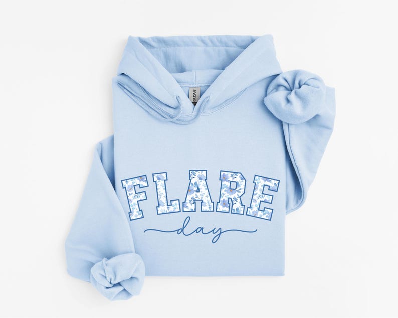 May include: Light blue hoodie with a floral print design that says "FLARE day" in a blue and white collegiate font.