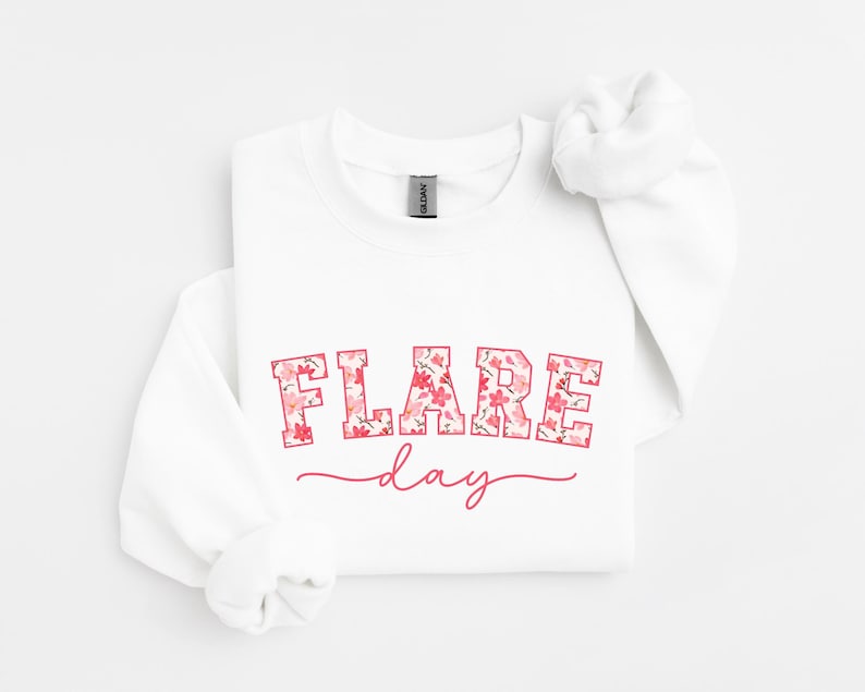 May include: White sweatshirt with a pink floral print that says "FLARE day" in a pink outline.