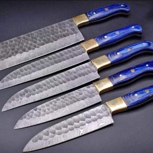 May include: Set of six kitchen knives with blue and gold handles. The blades are made of Damascus steel and have a hammered finish.